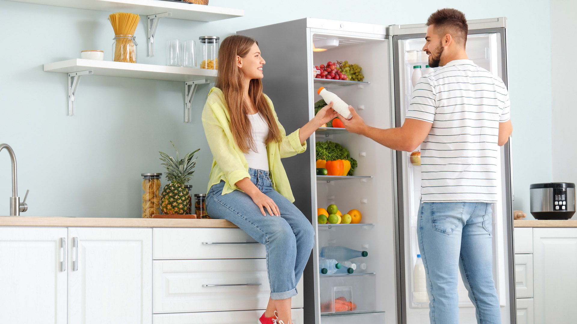 Mann gibt einer Frau einen Drink aus dem Kühlschrank Beko/Grundig 6616057 RSNE415T34XPN